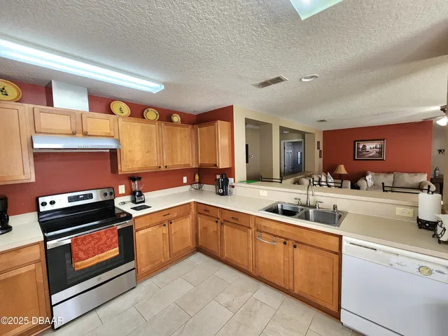 a kitchen with a sink a stove and cabinets