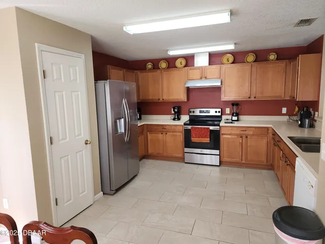 a kitchen with stainless steel appliances granite countertop a stove a sink and a refrigerator