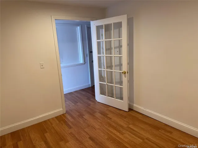 an empty room with wooden floor and entrance
