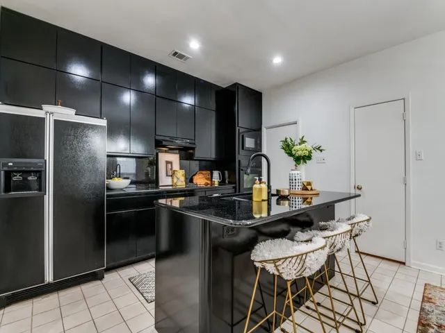 a kitchen with kitchen island a counter top space cabinets and stainless steel appliances
