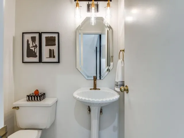 a bathroom with a toilet sink and mirror