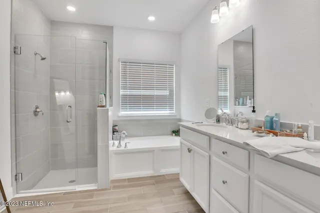 a bathroom with a double vanity sink mirror and shower
