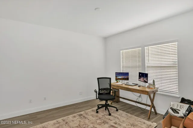 a view of a workspace with furniture and a window