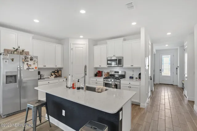 a kitchen with refrigerator and cabinets