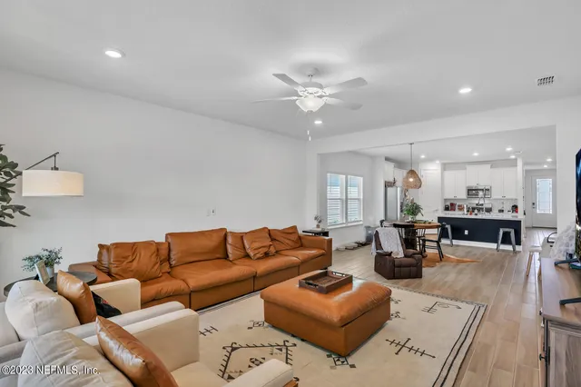 a living room with furniture ceiling fan and a rug