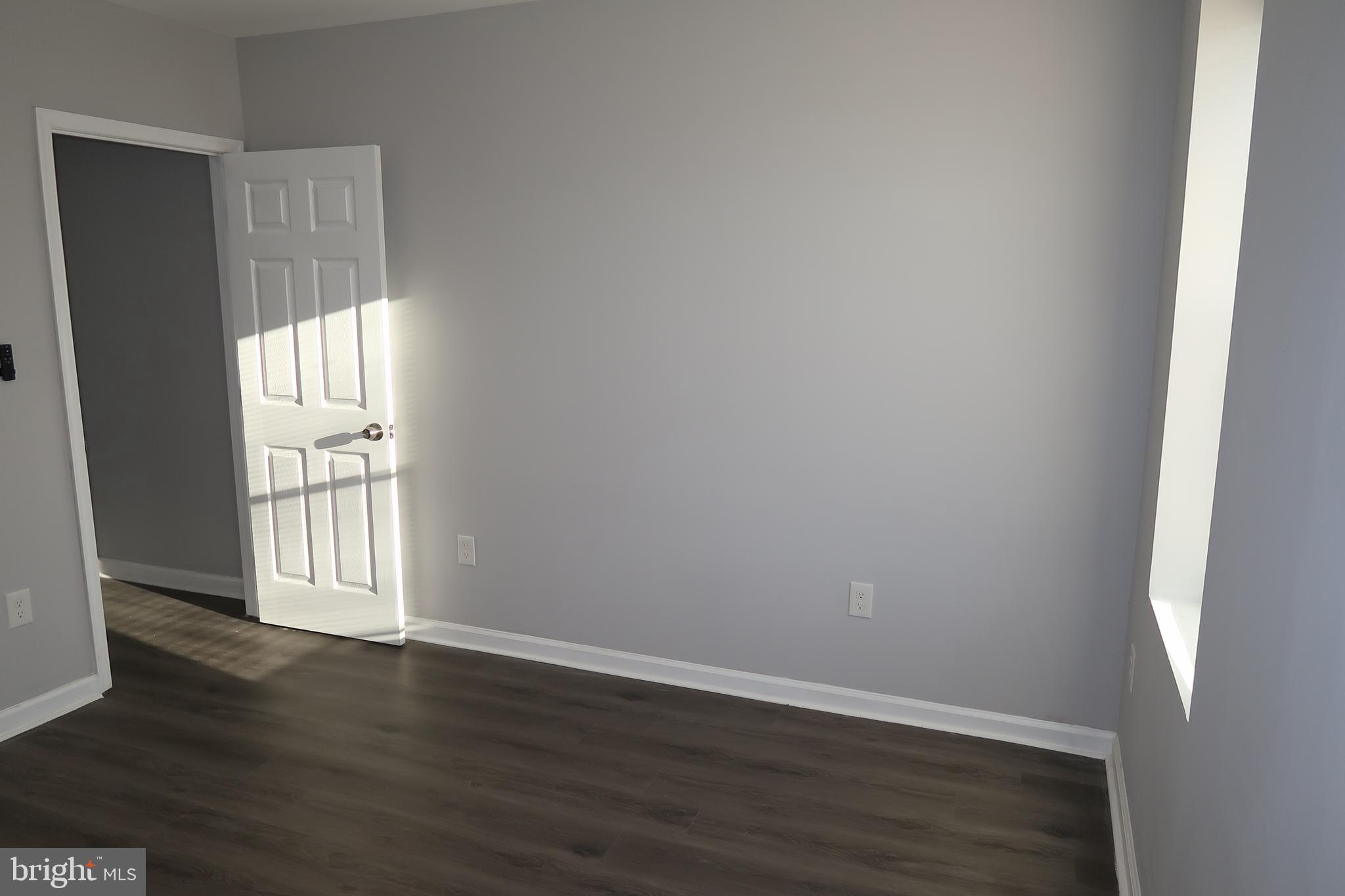 2833 Brendan Avenue, Unit 2 Baltimore, MD 21213 - Photo 14 of 17 an empty room with wooden floor and windows