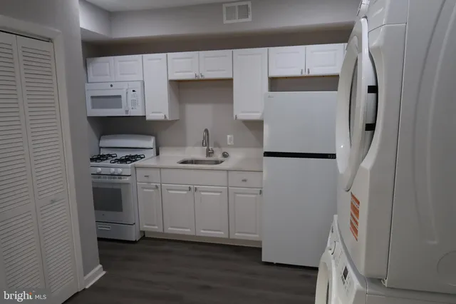 an empty room with wooden floor ceiling fan and windows