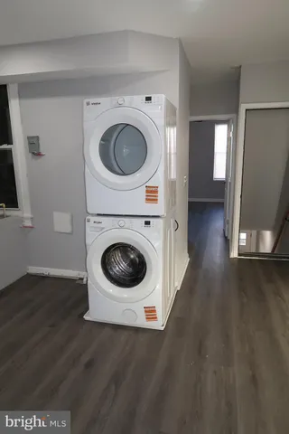 a view of a hallway with wooden floor and cabinet
