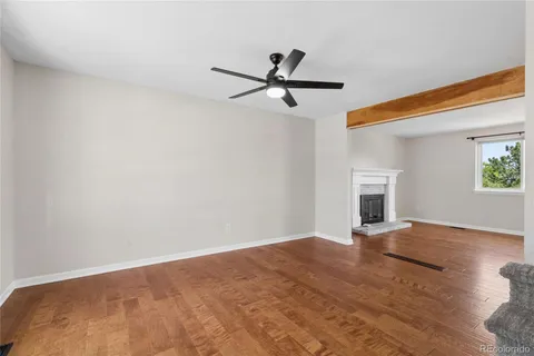 a view of empty room with wooden floor and fireplace