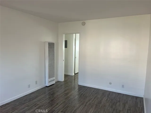 an empty room with wooden floor and entrance