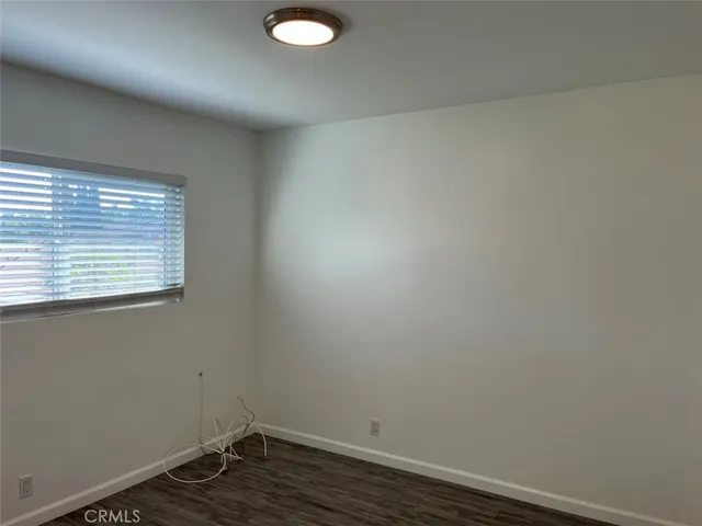 a view of a small space with wooden floor and a window