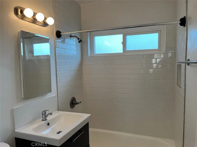 a bathroom with a sink a shower and a mirror