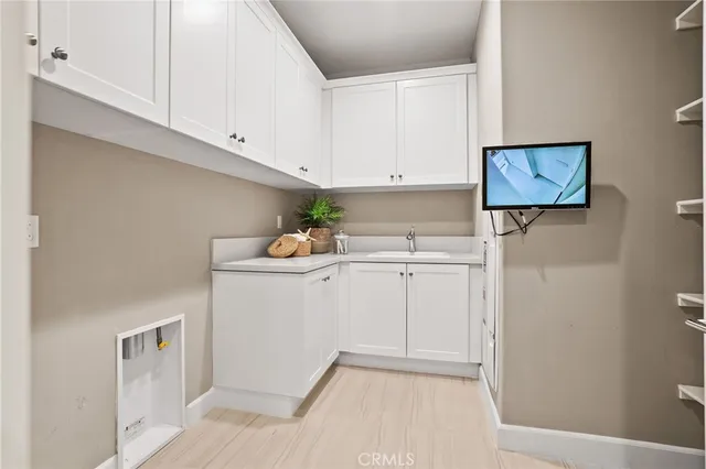 a utility room with cabinets washer and dryer