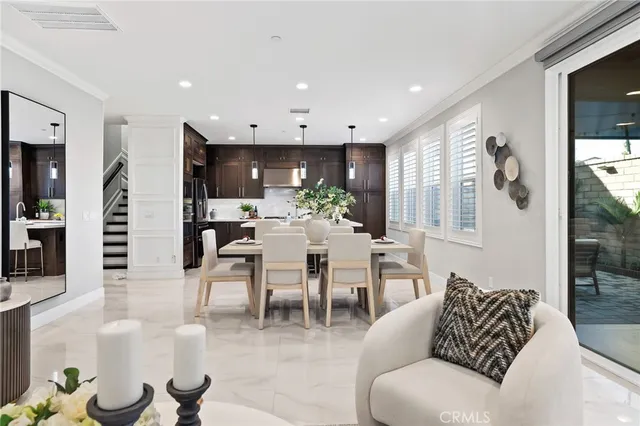 a living room with furniture kitchen view and a large window
