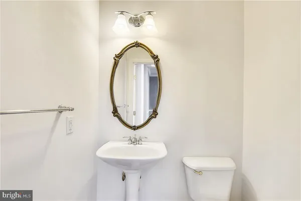 a bathroom with a toilet a sink and a mirror