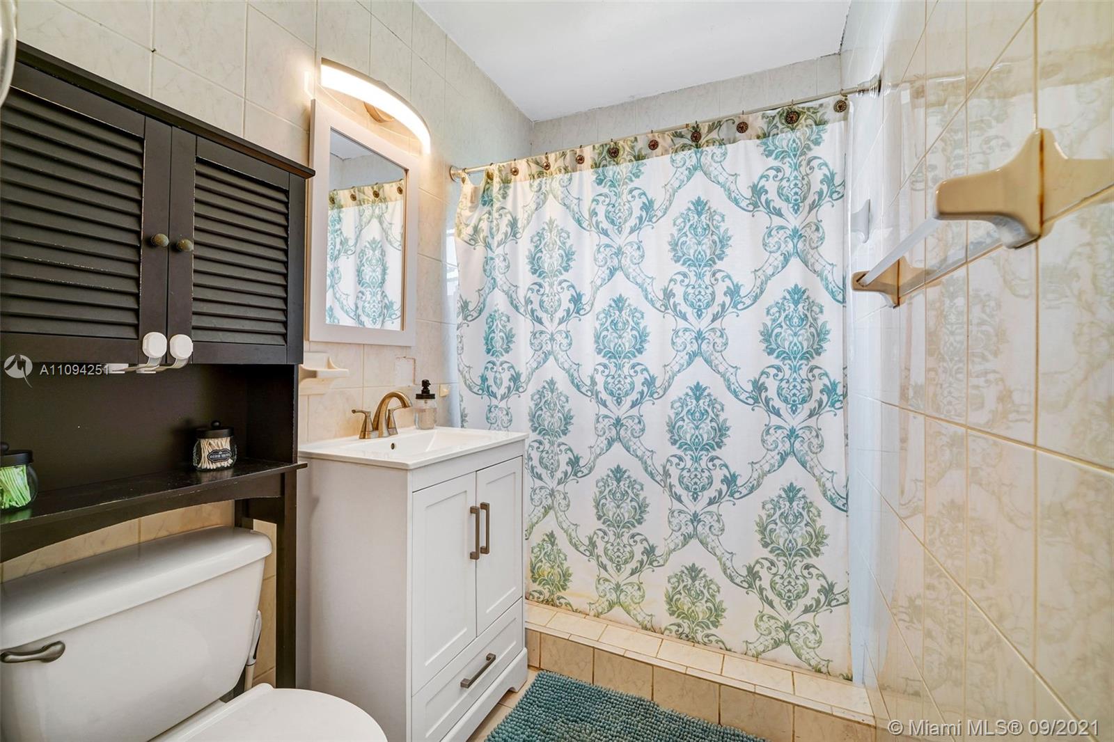 1431 Southwest 20th Street Miami, FL 33145 - Photo 18 of 32 a bathroom with a sink a toilet and shower curtain