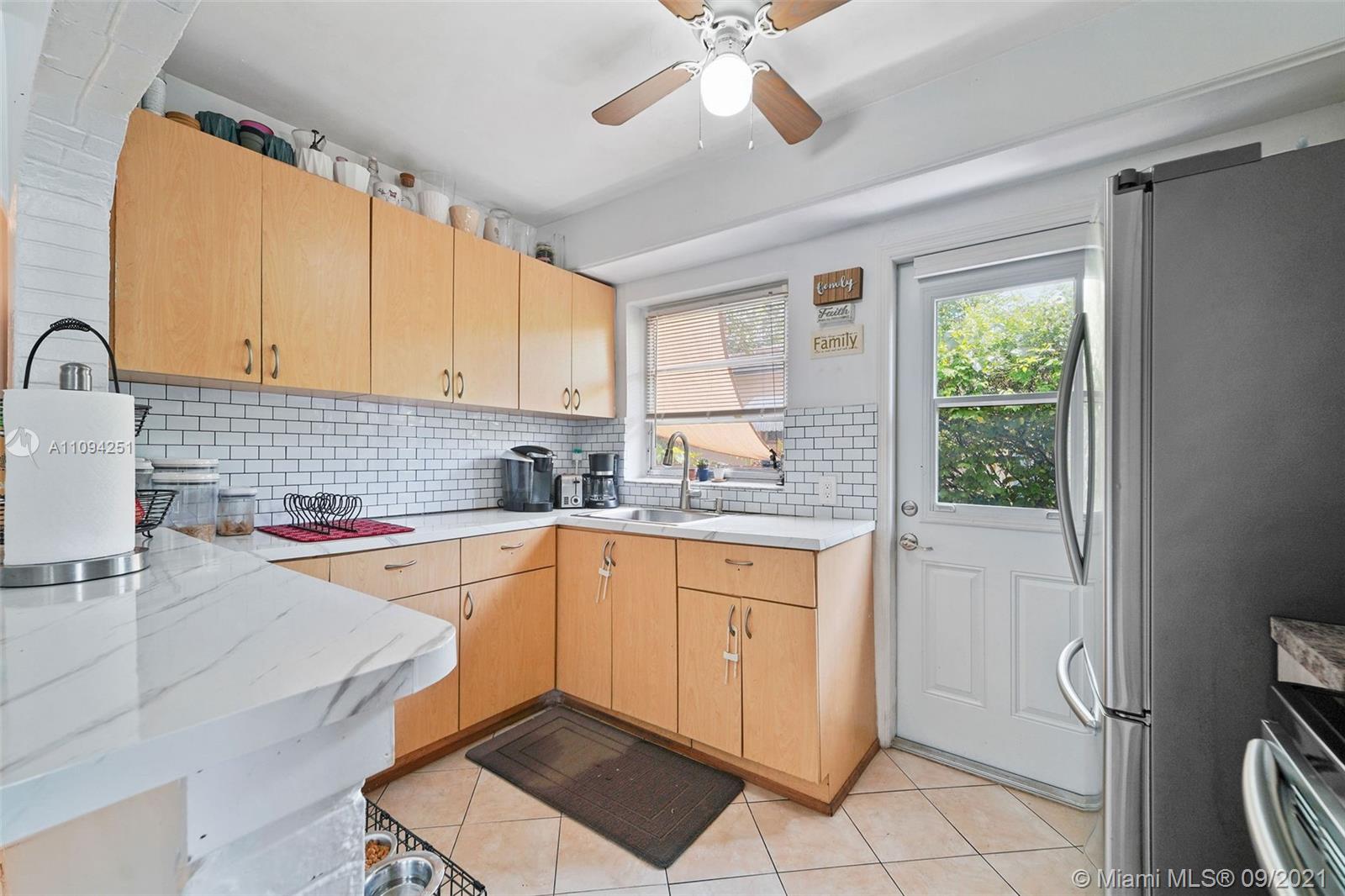 1431 Southwest 20th Street Miami, FL 33145 - Photo 27 of 32 a kitchen with a sink a stove cabinets and a window