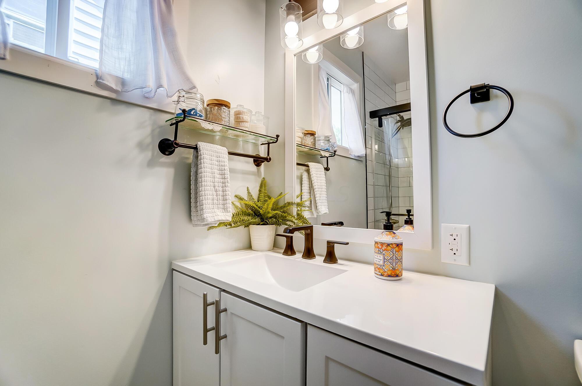 106 Demorest Road Columbus, OH 43204 - Photo 18 of 37 Gorgeous updated full bath! Tiled flooring, large walk in tiled shower with glass door! New sink/vanity, mirror and lighting fixture.