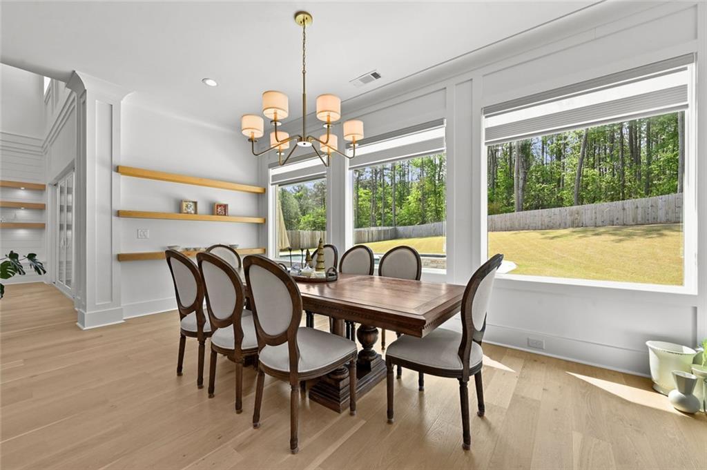 2694 Thompson Mill Road Buford, GA 30519 - Photo 31 of 70 a dining room with furniture a chandelier and wooden floor