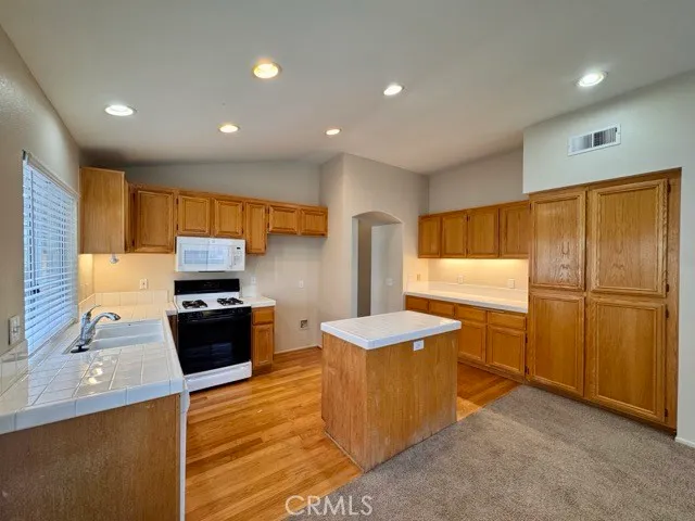 a view of a kitchen with wooden floor and staircase