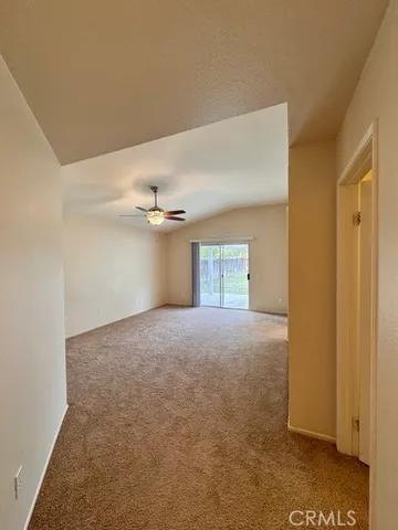 an empty room with closet and a ceiling fan