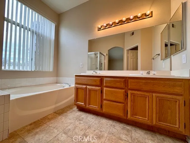 a bathroom with a tub sink and mirror