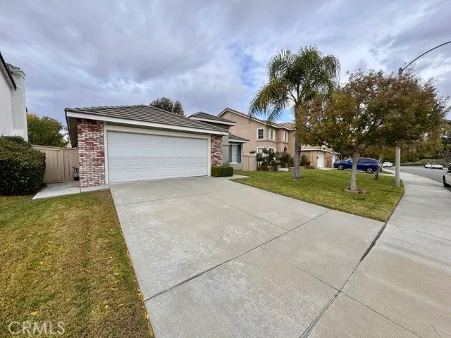 a front view of a house with a yard and trees