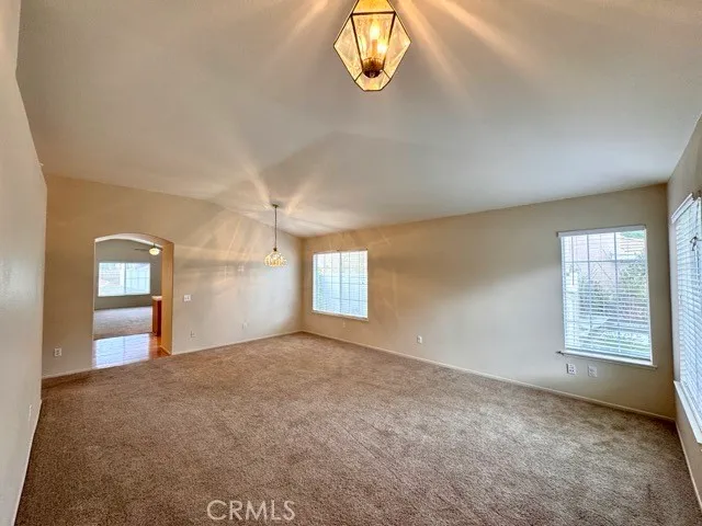 a view of a big room with a ceiling fan and entryway