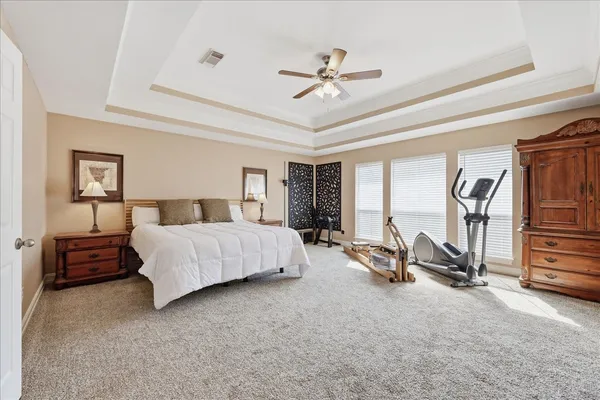 a bedroom with a bed a couch and gym equipment