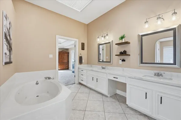 a bathroom with a bathtub a mirror a double vanity sink and vanity