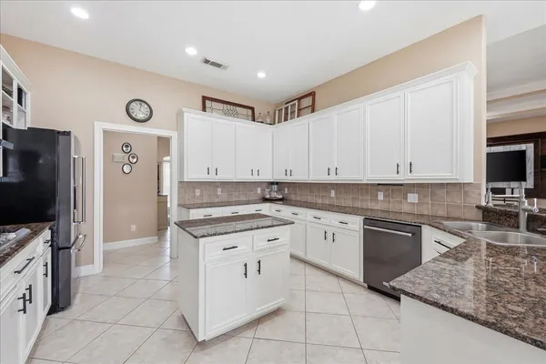 a kitchen with granite countertop cabinets stainless steel appliances and a counter space