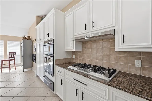 a kitchen with stainless steel appliances granite countertop a stove a refrigerator and cabinets