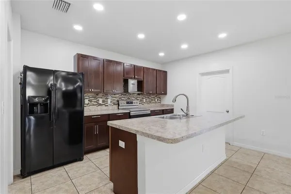 a kitchen with stainless steel appliances granite countertop a refrigerator and a sink