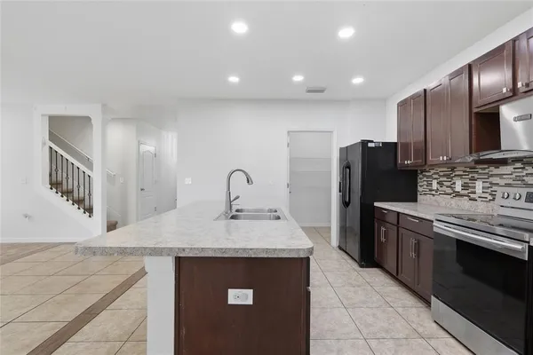 a kitchen with stainless steel appliances granite countertop a sink stove and refrigerator