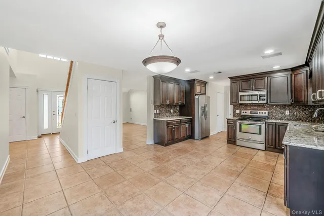 a kitchen with stainless steel appliances granite countertop a refrigerator and a stove top oven