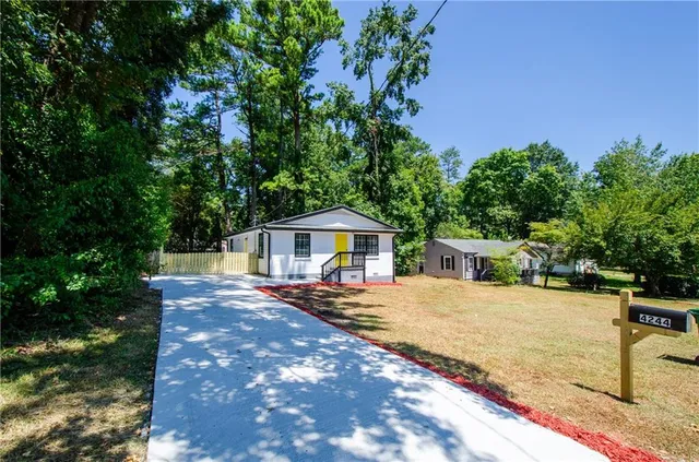 a view of a house with backyard and sitting area