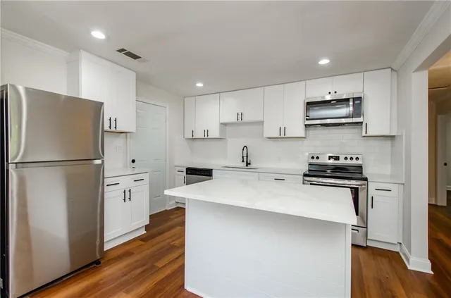 a kitchen with stainless steel appliances a refrigerator sink and stove