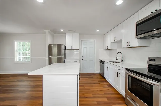 a kitchen with stainless steel appliances a refrigerator sink and microwave