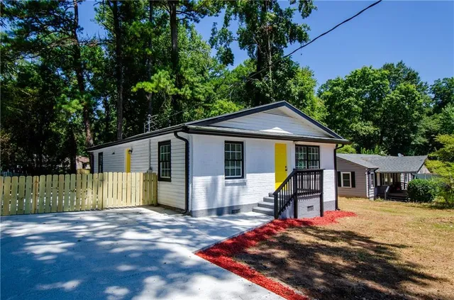 a view of a house with a small yard and a patio