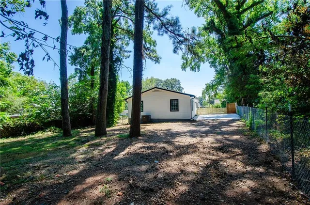 a view of a house with a tree in the forest