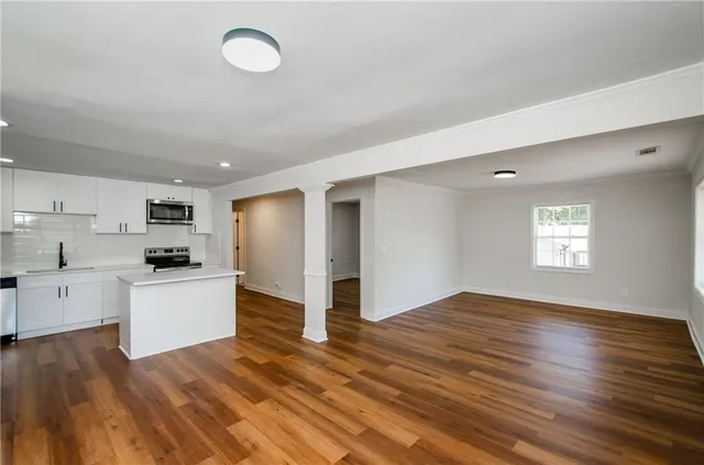a kitchen with a refrigerator and white cabinets