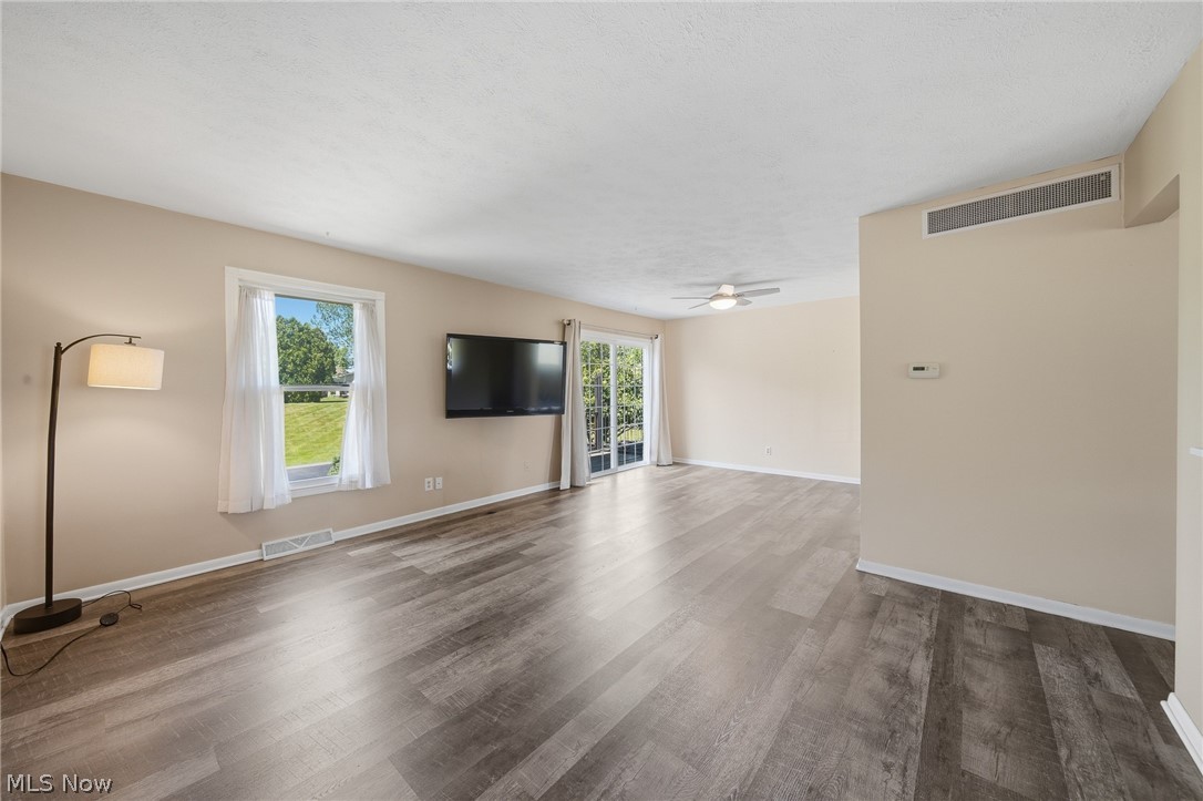 824 South Chillicothe Road, Unit 2 Aurora, OH 44202 - Photo 8 of 42 Spacious interior featuring wood-finish flooring, light-toned walls, a ceiling fan, and sliding glass doors to the exterior