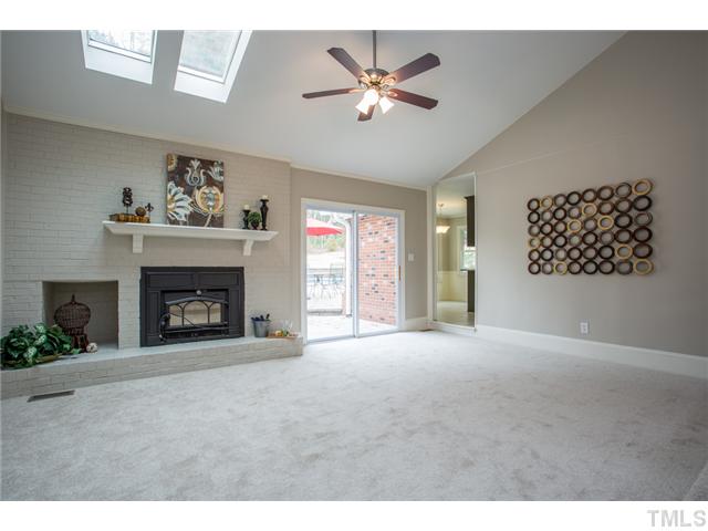 7929 Secluded Acres Road Apex, NC 27523 - Photo 5 of 16 Huge step-down family room with a wood stove and door leading out onto the patio.