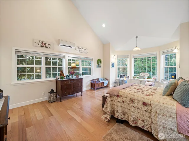 a bedroom with a bed and large windows