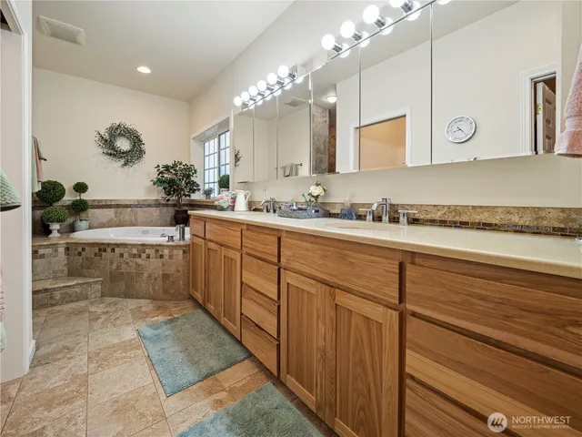 a spacious bathroom with a sink a mirror and a bathtub