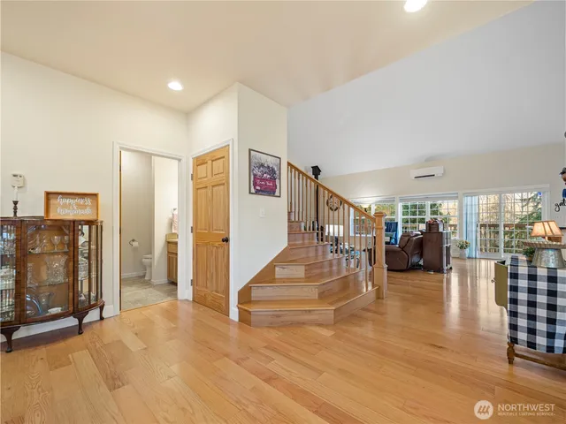 a view of a livingroom with entryway stairs and a living room