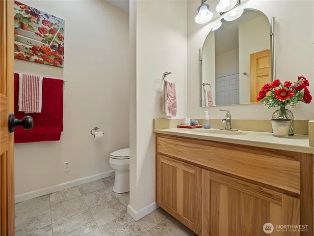 a bathroom with a granite countertop sink a toilet and a mirror