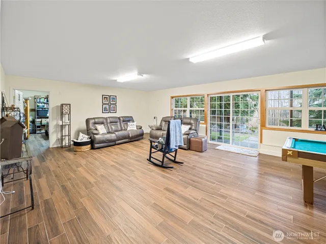 a living room with furniture and a table next to a large window