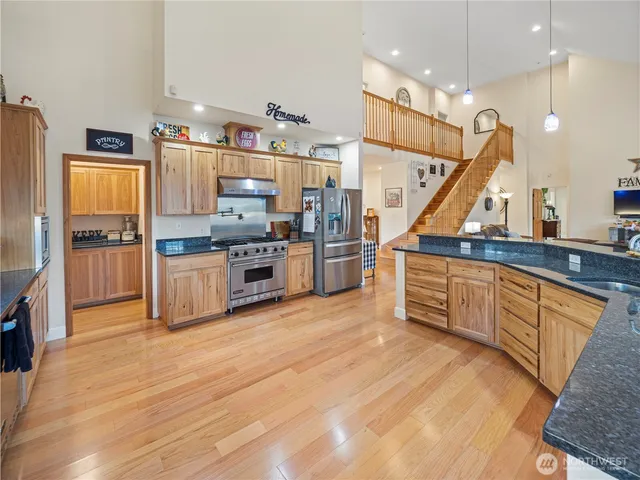a kitchen with stainless steel appliances granite countertop a refrigerator and a stove top oven