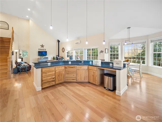 a large kitchen with stainless steel appliances granite countertop a large counter top a stove and a wooden floors